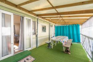 a small room with a table and a bench on a balcony at Mh310 La Tremblade in La Tremblade
