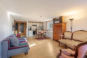 a living room with a couch and chairs and a kitchen at Zwei-Zimmer-Wohnung in Schopfheim in Schopfheim