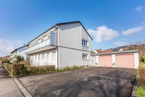 a white house with a parking lot at Zwei-Zimmer-Wohnung in Schopfheim in Schopfheim
