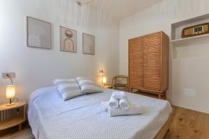 a white bedroom with a bed with towels on it at Casa Magnolia Loft in Seccheto