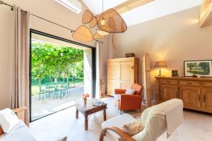 a living room with a sliding glass door to a patio at Tilleul enchanté in Malaucène