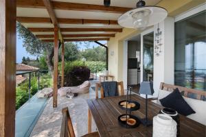 an outdoor patio with a wooden table and chairs at Villa Savi Lake View and Pool in Torri del Benaco