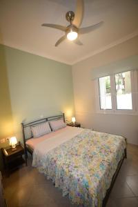 a bedroom with a bed and a ceiling fan at Nicol apartment in Koustáros