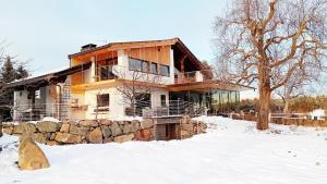 ein Haus im Schnee mit einer Steinmauer in der Unterkunft Kesselmoos in Deutschnofen