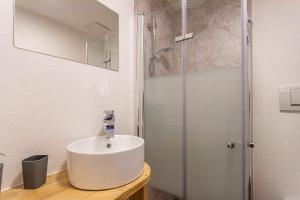 a white bathroom with a sink and a shower at Bergwelt C in Niederau +10 photos