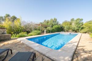 a swimming pool with blue water in a yard at S' Oratge in Islas Baleares