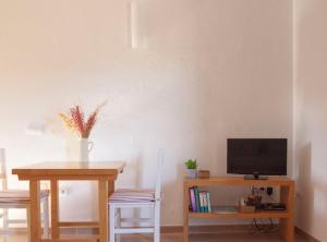 a dining room with a table and a television at Vivendes Adelina - Escapada Formentera in Es Pujols