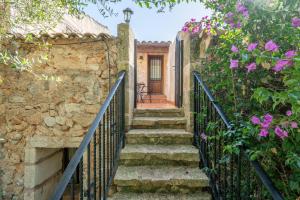 a set of stairs leading up to a house with flowers at S' Oratge in Islas Baleares