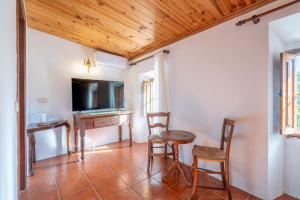 a living room with a table and chairs and a television at S' Oratge in Islas Baleares