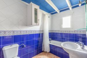 a blue and white bathroom with a toilet and a sink at Cala Serena Beach in Felanitx +17 photos