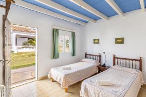 a bedroom with two beds and a large window at Cala Serena Beach in Felanitx