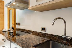 a kitchen with granite counter tops and a sink at Stoffel Apartments Martina in Selva