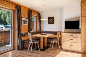 a kitchen with a table and chairs and a television at Stoffel Apartments Martina in Selva +14 photos
