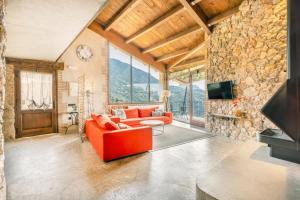 a living room with a red couch and a stone wall at El Cobert De Lera in Oden