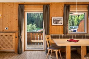 a dining room with a table and a window at Stoffel Apartments Martina in Selva