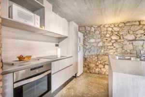 a small kitchen with a sink and a microwave at El Cobert De Lera in Oden +17 photos