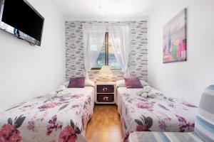 a bedroom with two beds and a tv and a window at Jolly suite puertorico Beach in Mogán +22 photos