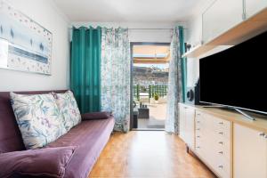 a living room with a couch and a flat screen tv at Jolly suite puertorico Beach in Mogán