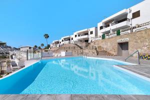 a large swimming pool in front of a building at Jolly suite puertorico Beach in Mogán