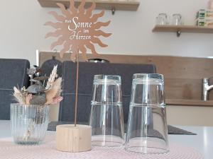 a table with three glasses and a sign on it at Ferienwohnung Sonnenblick und Relax in Nieder-Röhre +26 photos