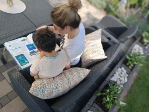 a woman and a boy sitting on a bench with pillows at Ferienwohnung Sonnenblick und Relax in Nieder-Röhre