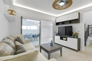 a living room with a couch and a tv at Dúplex El Equilibrio in Playa Honda