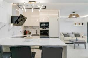 a white kitchen with a table and chairs at Dúplex El Equilibrio in Playa Honda