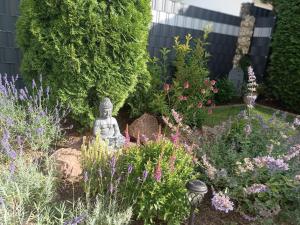 a garden with a statue in the middle at Ferienwohnung Sonnenblick und Relax in Nieder-Röhre