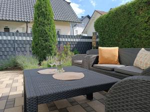 a patio with a table and chairs with wine glasses at Ferienwohnung Sonnenblick und Relax in Nieder-Röhre