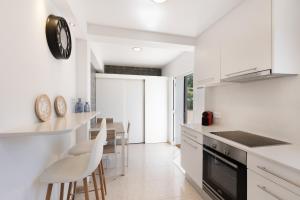 a kitchen with white cabinets and a table and chairs at V206 Villa Isabel in Son Bou