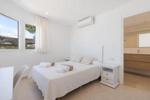 a white bedroom with a white bed and a window at V206 Villa Isabel in Son Bou +27 photos