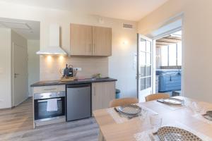 a kitchen and dining room with a table and chairs at Viognier - logement avec jacuzzi in Ruoms +15 photos