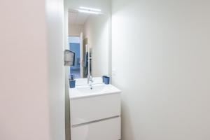 a white bathroom with a sink and a mirror at Viognier - logement avec jacuzzi in Ruoms