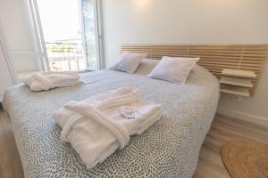 a bedroom with two towels on a bed with a window at Viognier - logement avec jacuzzi in Ruoms