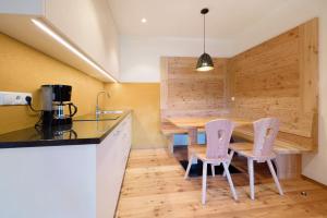 a kitchen with a table and chairs in a room at Teutenhofer Apfel in Feldthurns