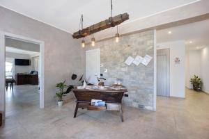 a living room with a stone wall and a wooden table at Antichi Ricordi - Il Pollaio in Marina di Andora