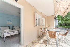 a patio with a table and chairs and a bed at Giorgio studios-apartments 1 in Nikiana