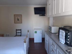 a kitchen with a white refrigerator and a microwave at De Kothuize 4 in Graaff-Reinet