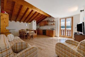 a living room with couches and a kitchen at Casa Vendrogno in Bellano