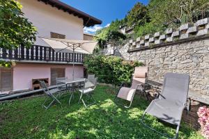 a patio with a table and chairs and an umbrella at Casa Vendrogno in Bellano
