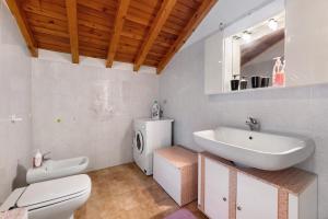 a bathroom with a toilet and a sink at Casa Vendrogno in Bellano +21 photos