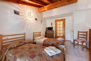 a hotel room with two beds and a television at Casa Vendrogno in Bellano