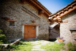 a stone house with a wooden door in a yard at Civico 2 in Marmora