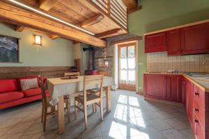 a kitchen with red cabinets and a table and chairs at Civico 2 in Marmora