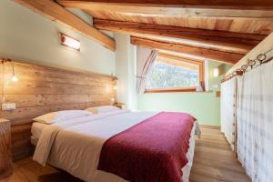 a bedroom with a large bed with a wooden wall at Civico 2 in Marmora +2 photos