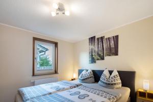 a bedroom with two beds and a window at Ferienhäuser Hainichhöhe in Hörselberg-Hainich
