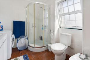 a white bathroom with a shower and a toilet at Adega Maciel in Lajido +19 photos