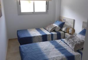 a bedroom with two beds and a couch and a window at Great apartment with pool - jacuzi in Villacosta +18 photos