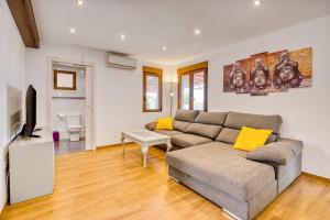 ein Wohnzimmer mit Sofa und Fernseher in der Unterkunft Violeta in Macastre