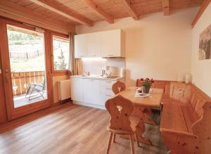 a kitchen with a wooden table and a wooden floor at Apartment Toni - Obermösslhof in Lana +18 photos